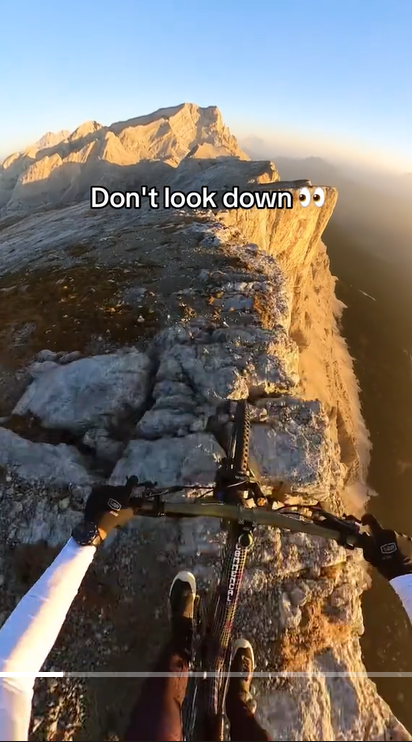 A man bikes through a rocky mountain ridge