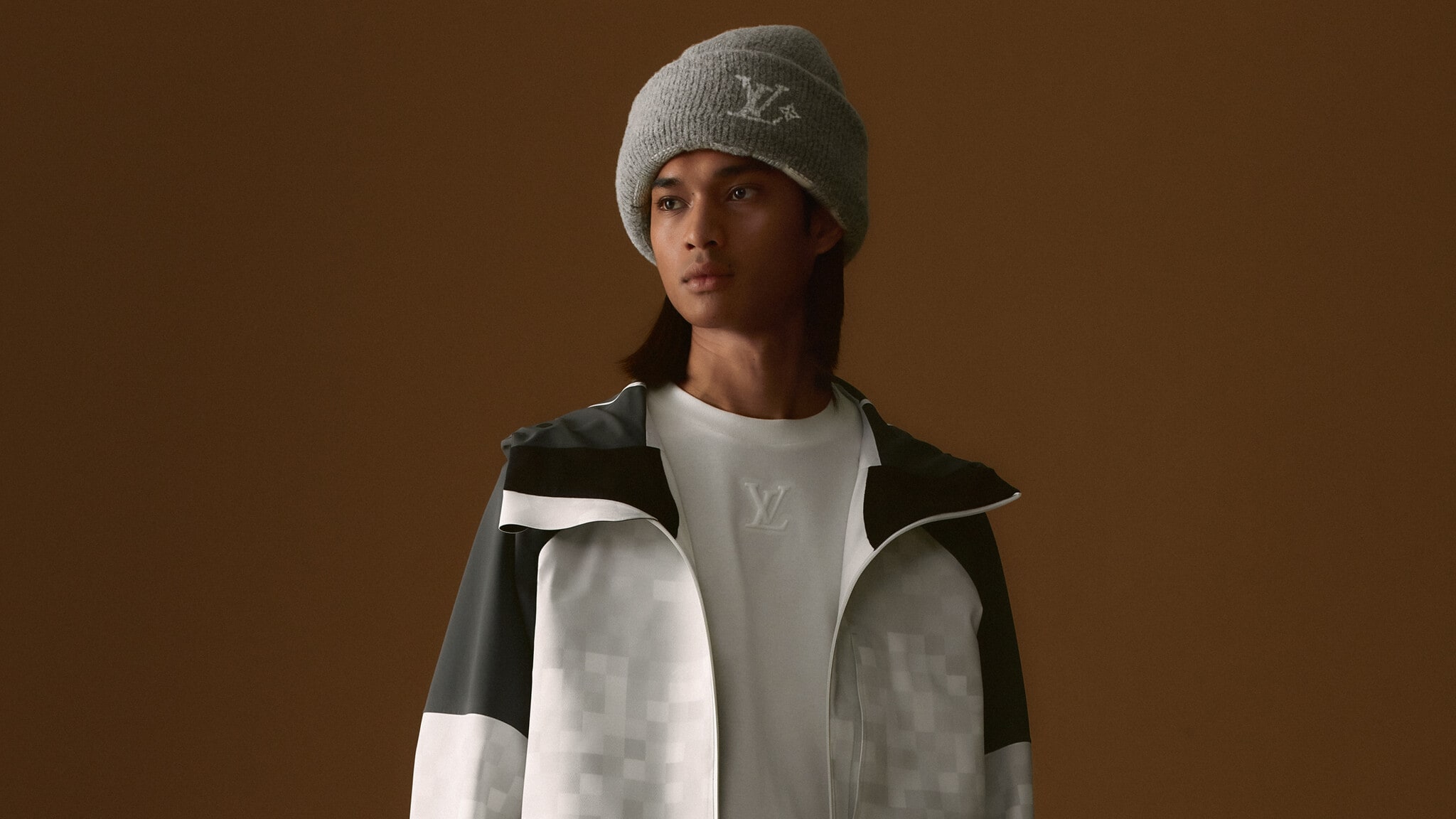 A man is wearing a grey beanie hat