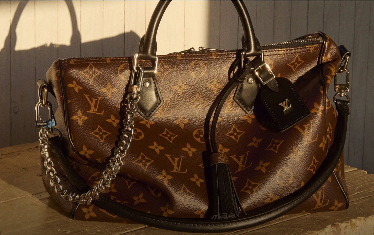 A brown leather bag stamped with monogram and floral icons