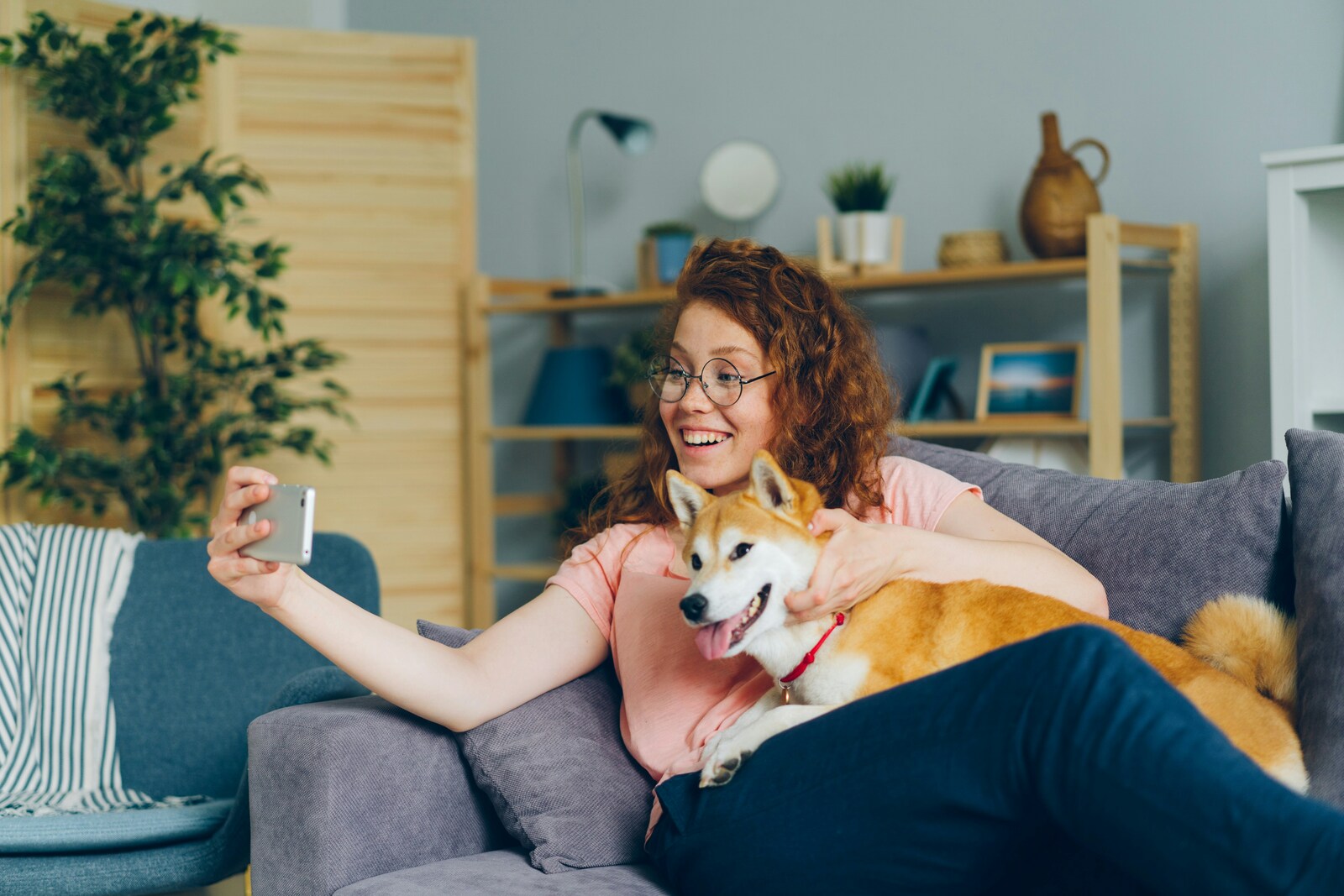 A woman sitting on a couch holding a dog.