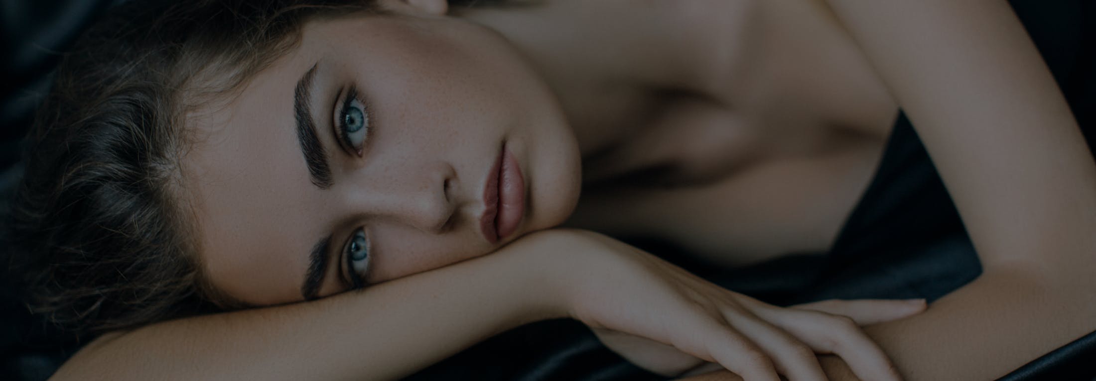 close up of a woman laying down with her face on her arm