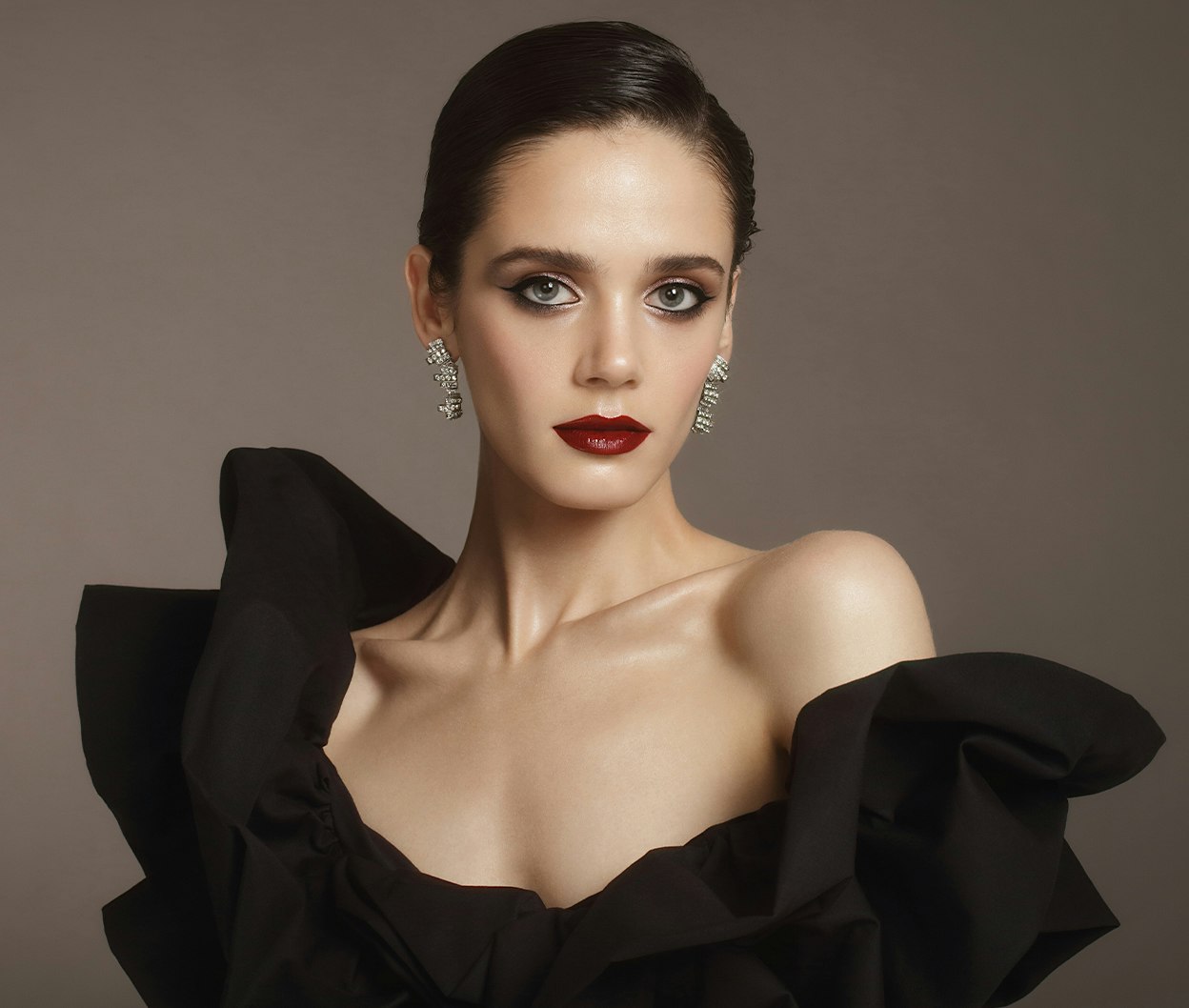 woman in a black dress with a red lipstick and earrings