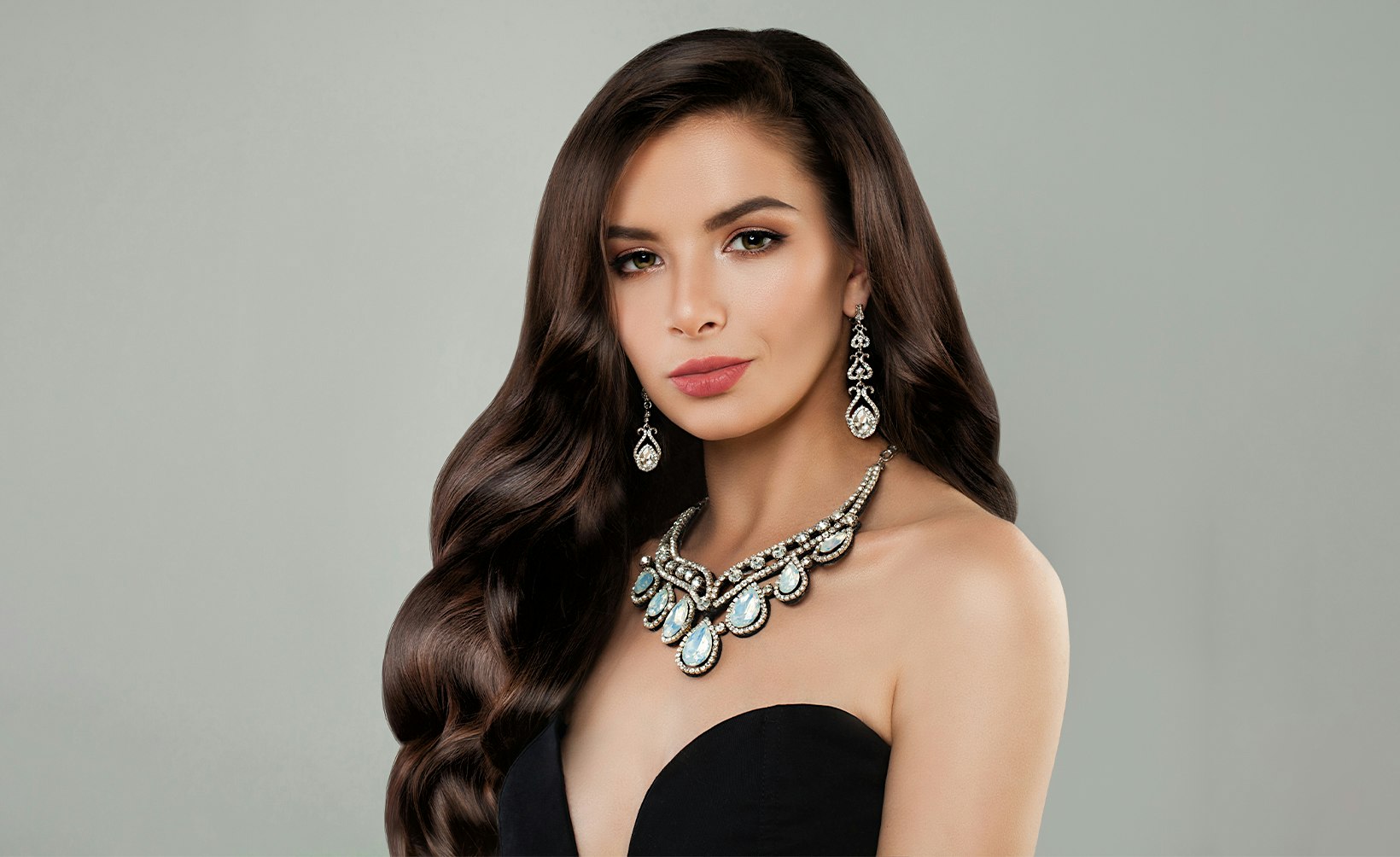 woman with long dark hair wearing a black dress and a necklace
