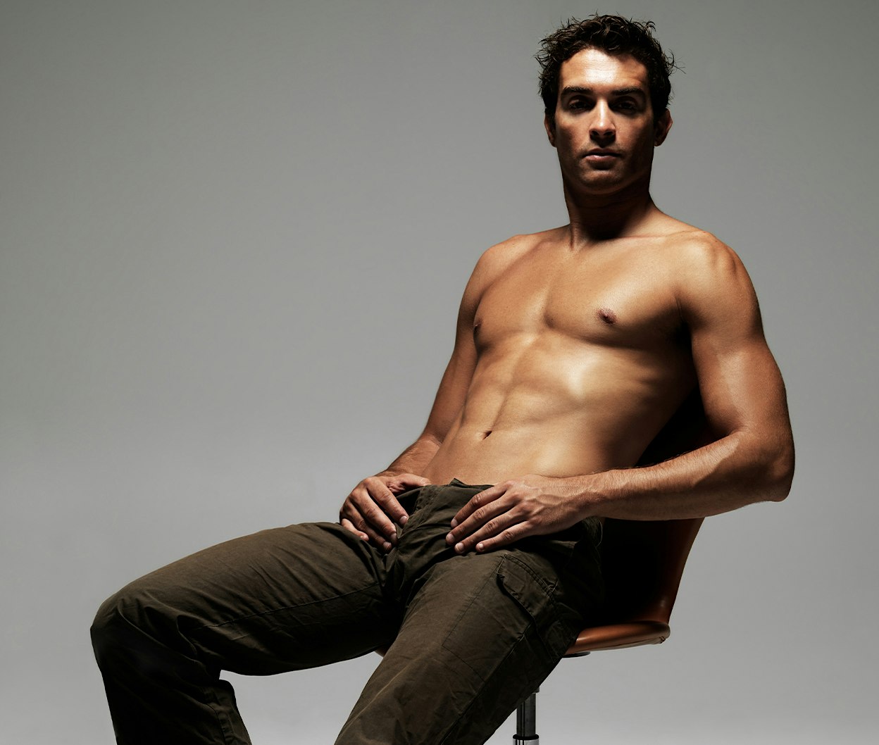 man sitting on a chair with his shirt off
