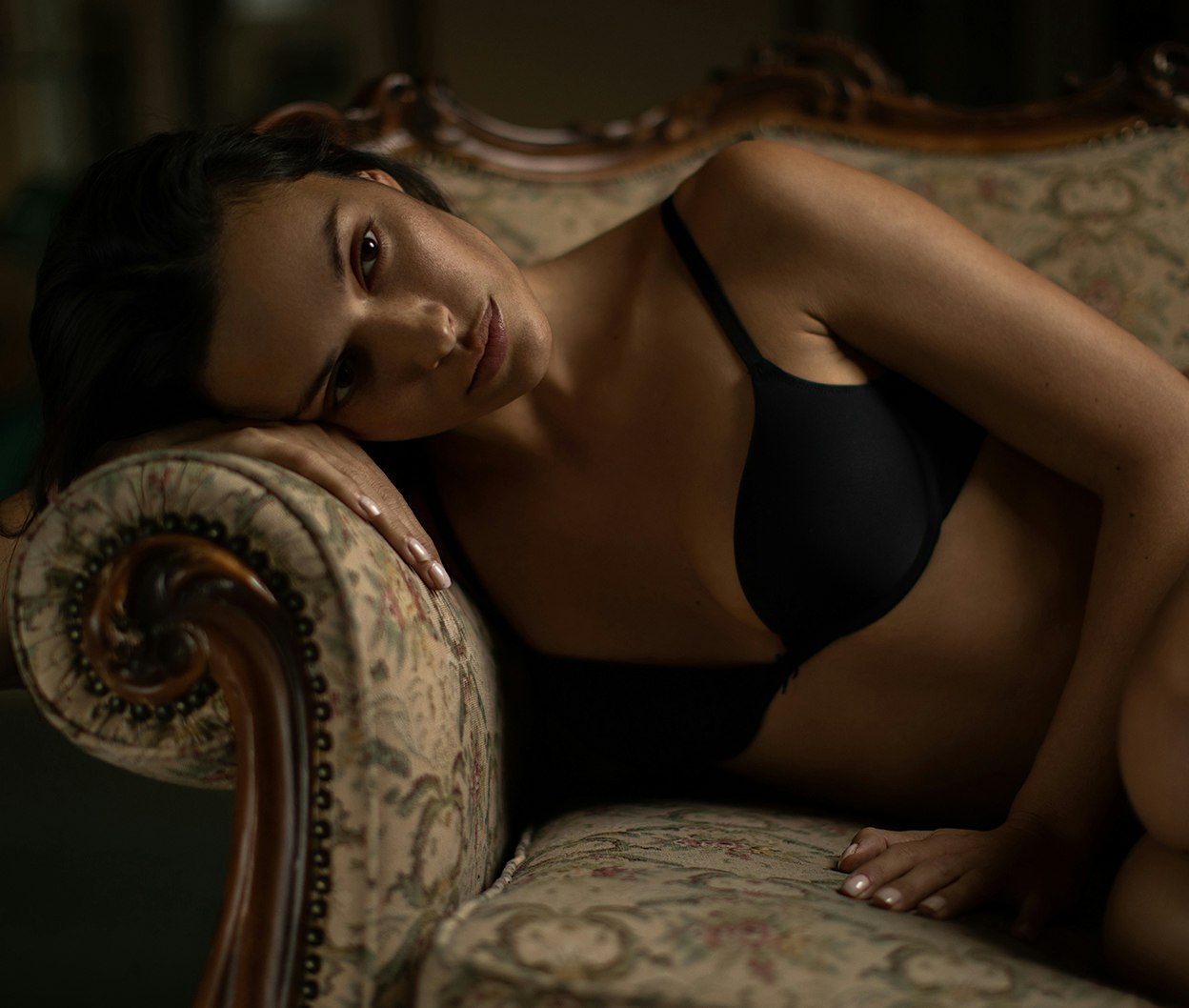 woman in black bra top laying on a couch