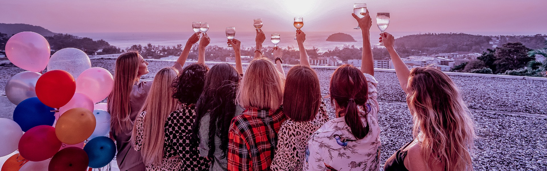 Donne in viaggio brindano al tramonto sul mare