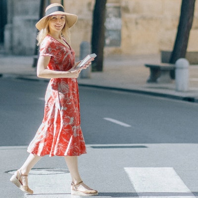 Donna in viaggio con vestito rosso e cappello di paglia