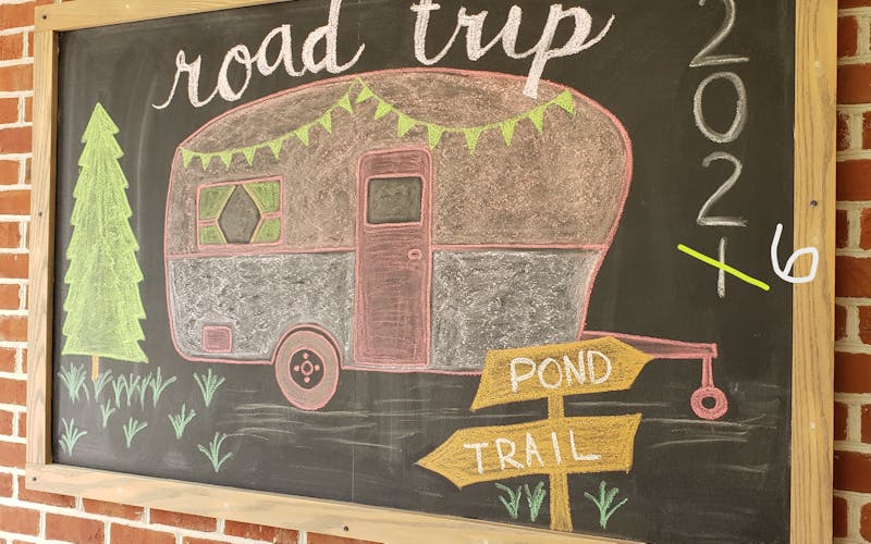 chalkboard drawing of camper with title road trip