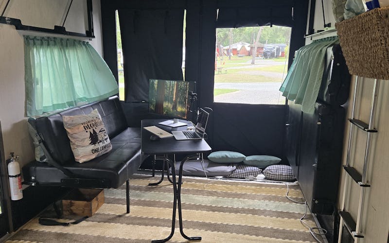 office set up in garage of toy hauler camper with laptop and monitor on small table
