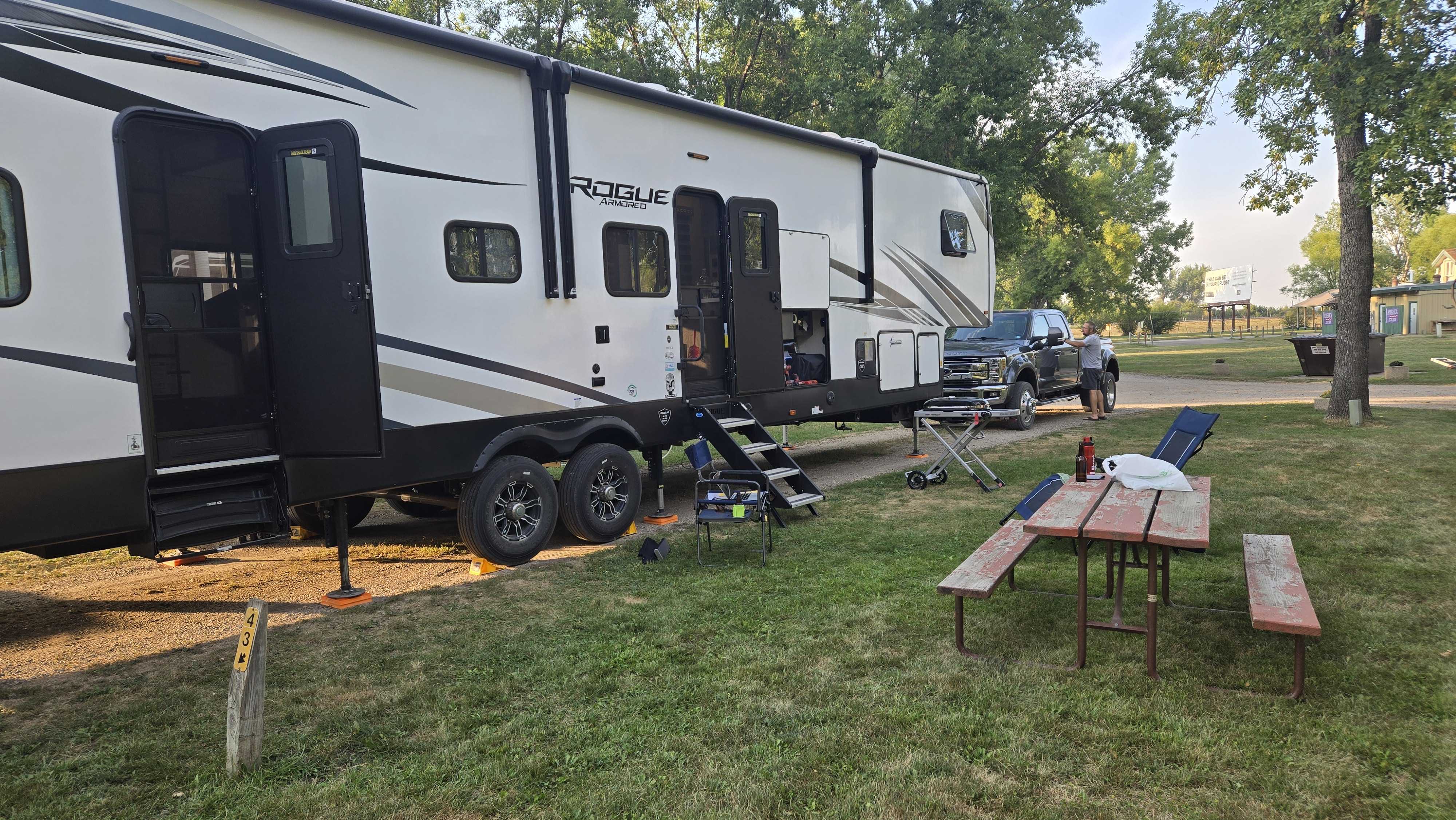 front of camper and picnic table, parked in a campground