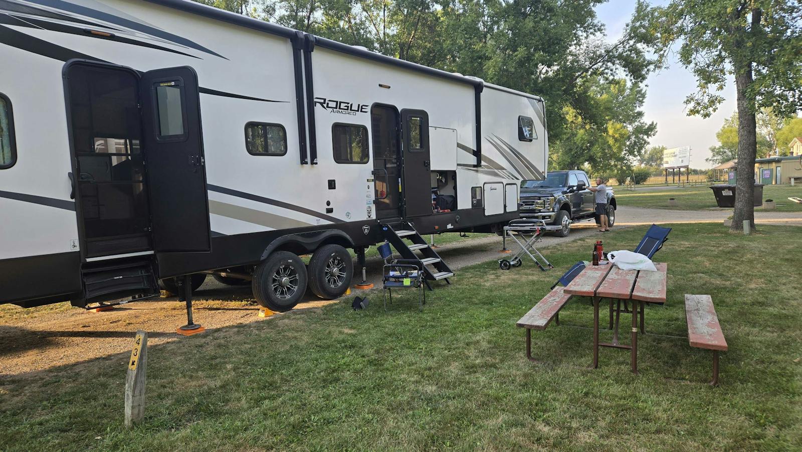 front of camper and picnic table, parked in a campground
