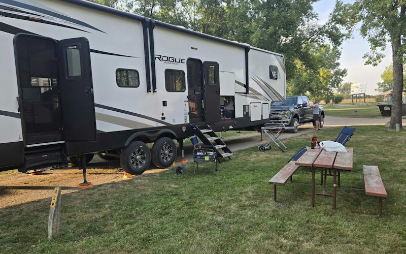 front of camper and picnic table, parked in a campground