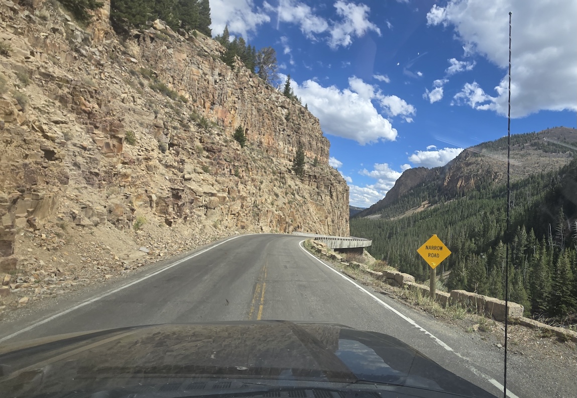 dangerous road with sharp grade and hairpin turn around a mountain taken from truck window