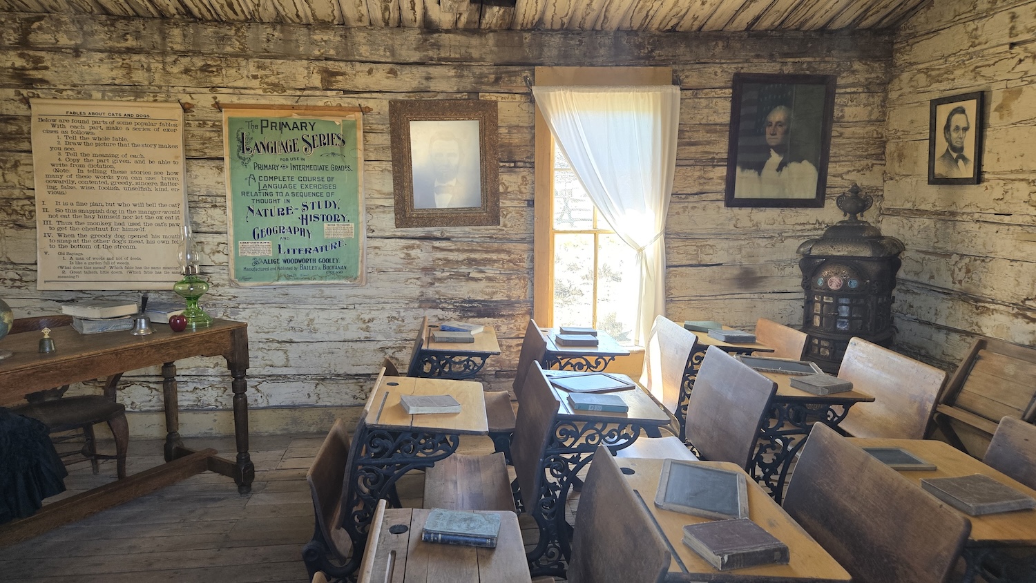 an old school house cabin from the 1800s with children's and teacher's desk