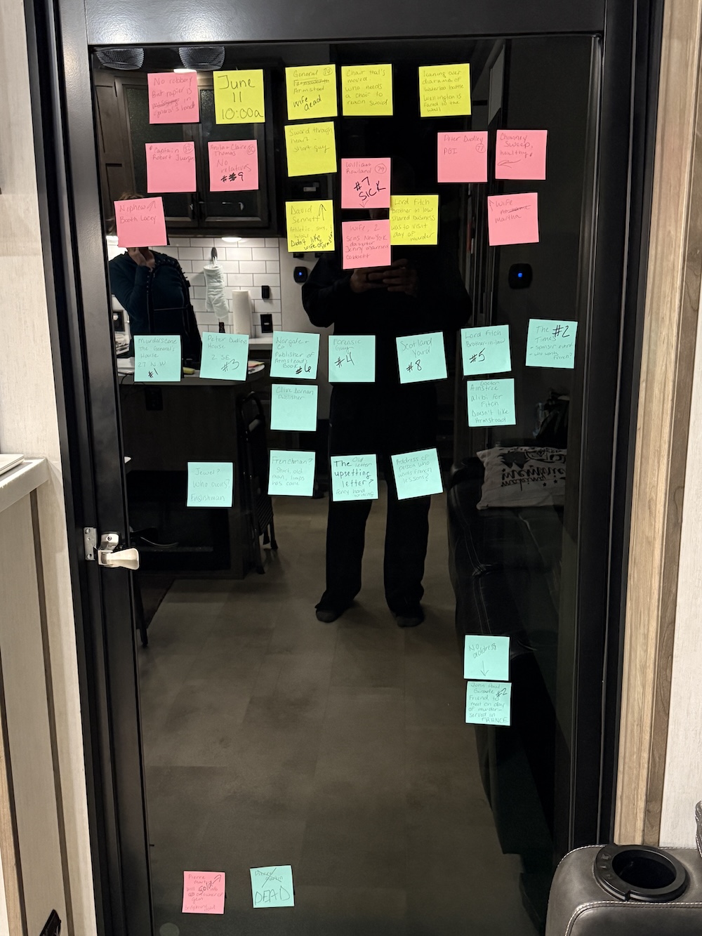 our murder board with sticky notes on the glass garage door