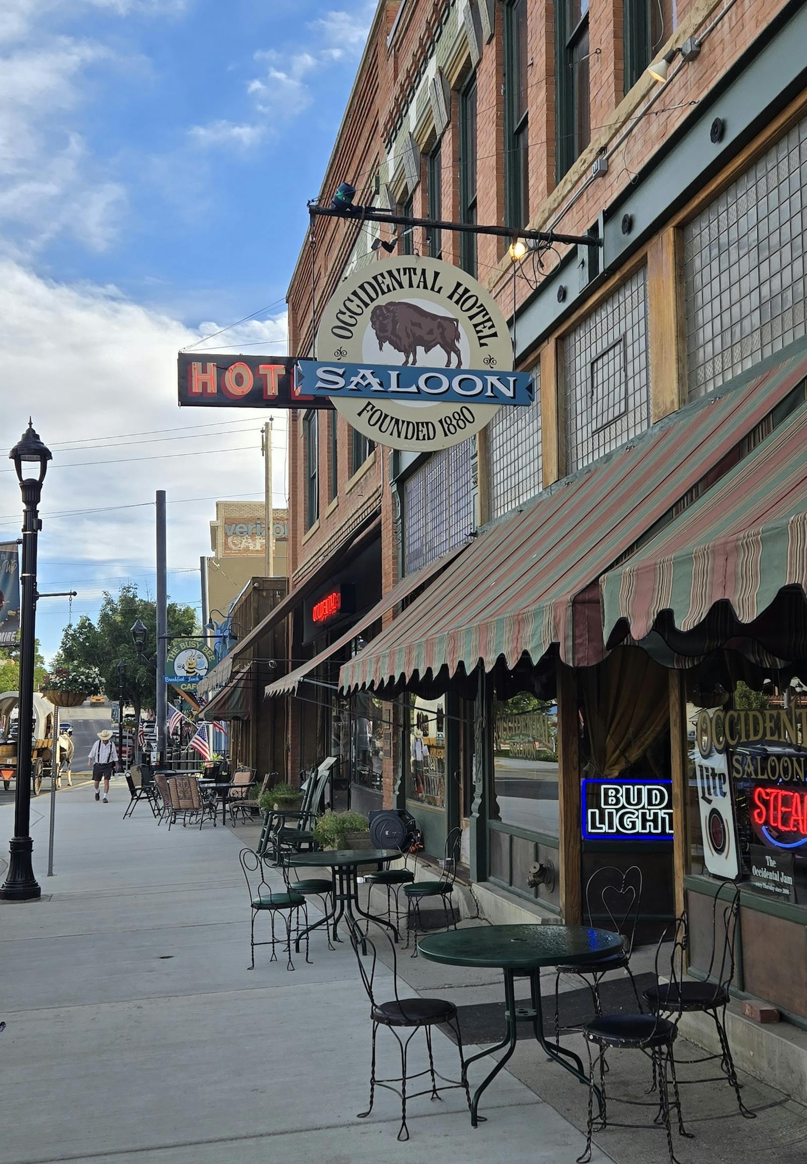 front of the Occidental Hotel in Buffalo, WY with saloon sign and metal tables along the sidewalk
