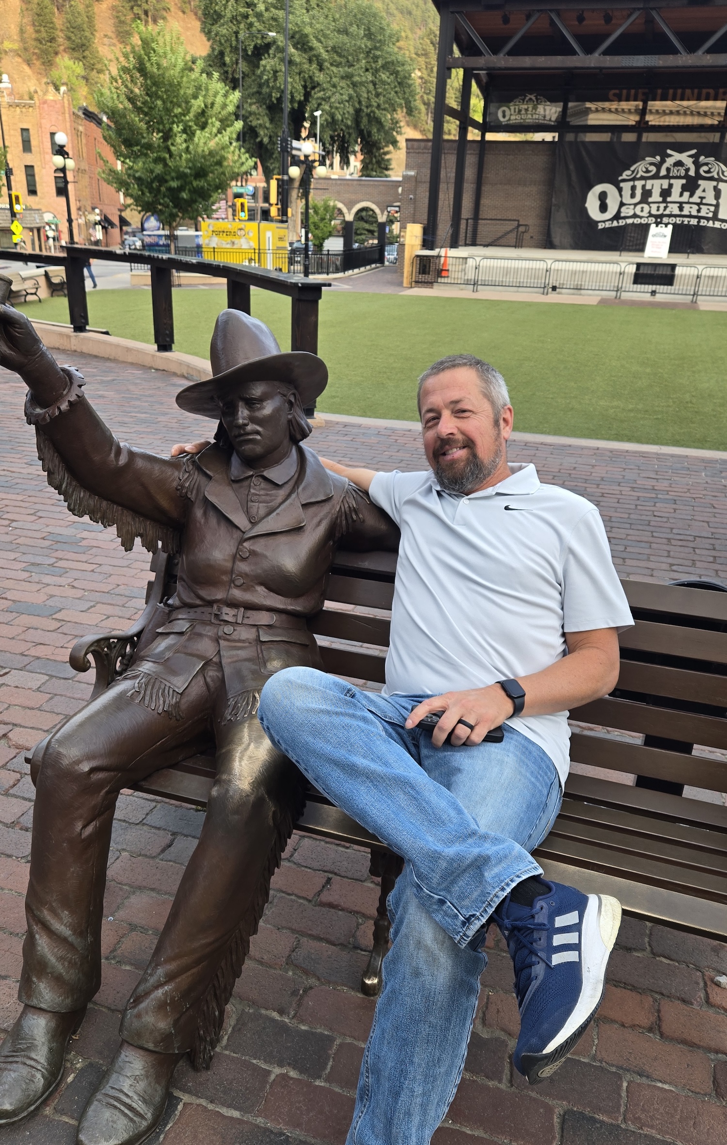 Jason posing next to seated statue of Calamity Jane