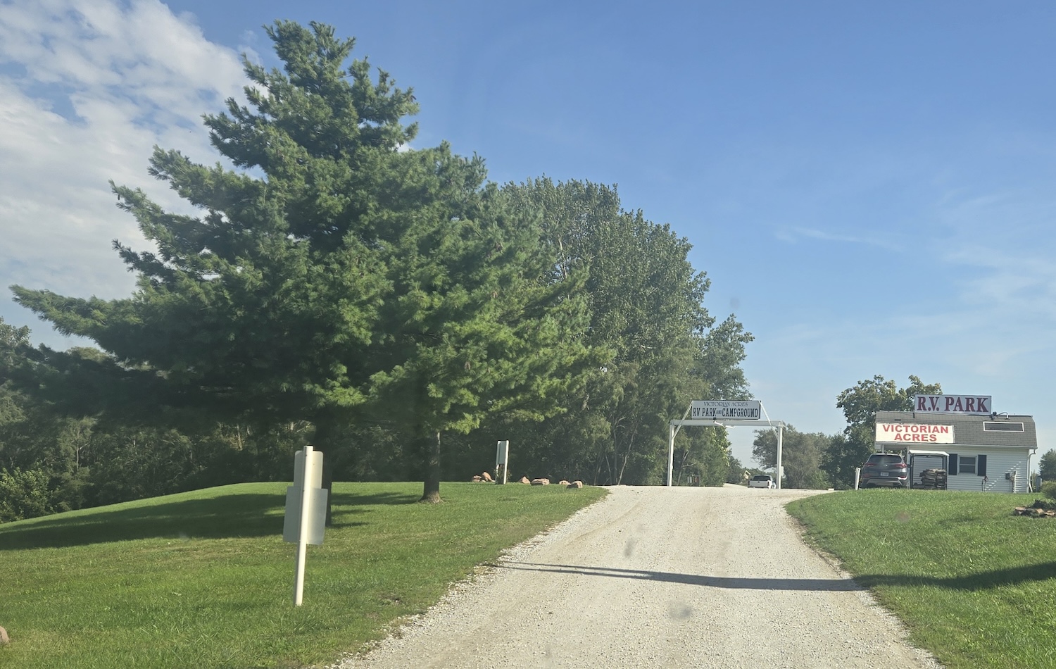 entrance of Victorian Acres RV park with large gravel drive and park office to the right