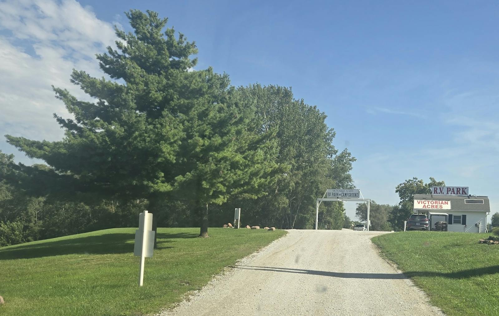 entrance of Victorian Acres RV park with large gravel drive and park office to the right