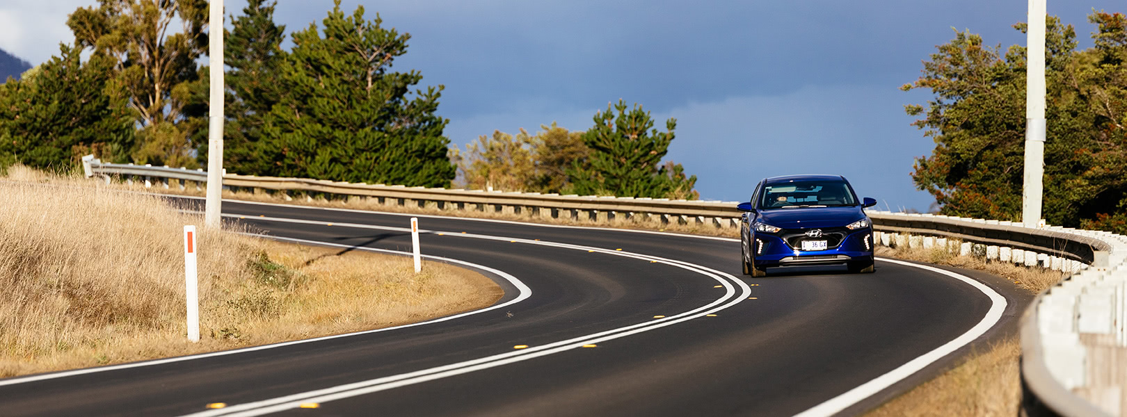 Electric car driving on windy road