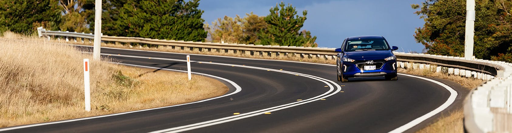 Electric car driving on windy road