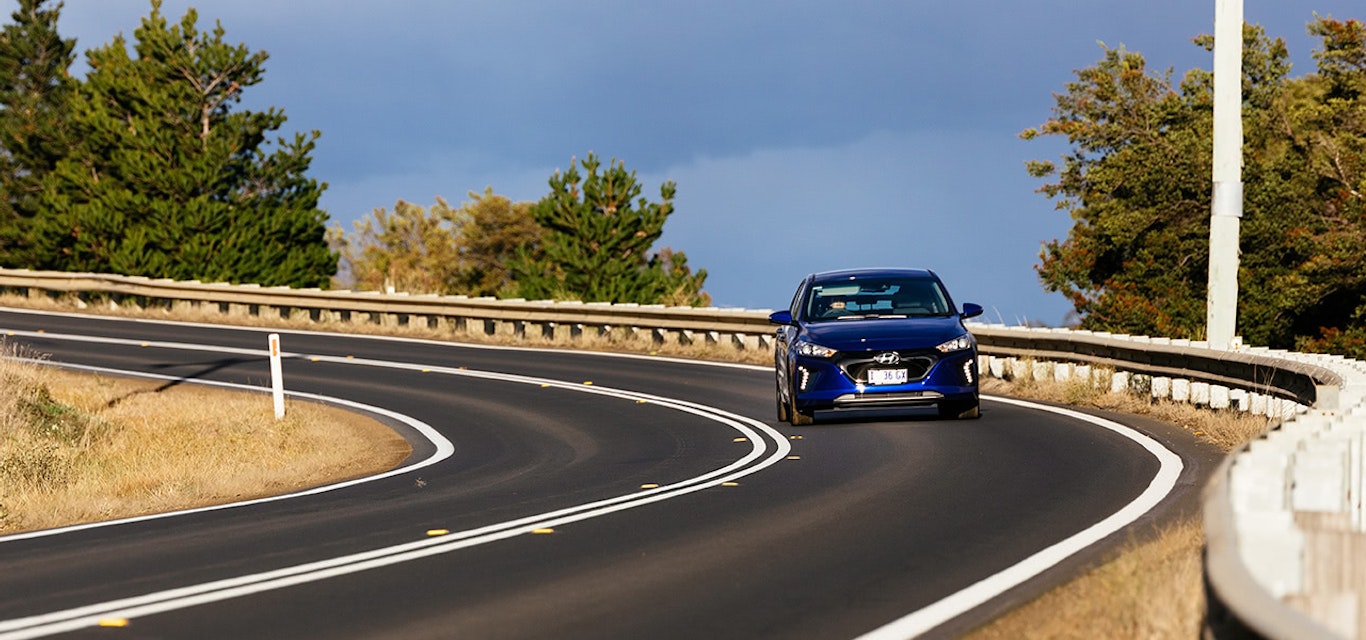 Electric car driving on windy road
