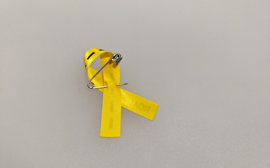 Yellow ribbon bow with a safety pin 