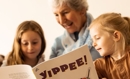 A grandmother reads to her grandchildren