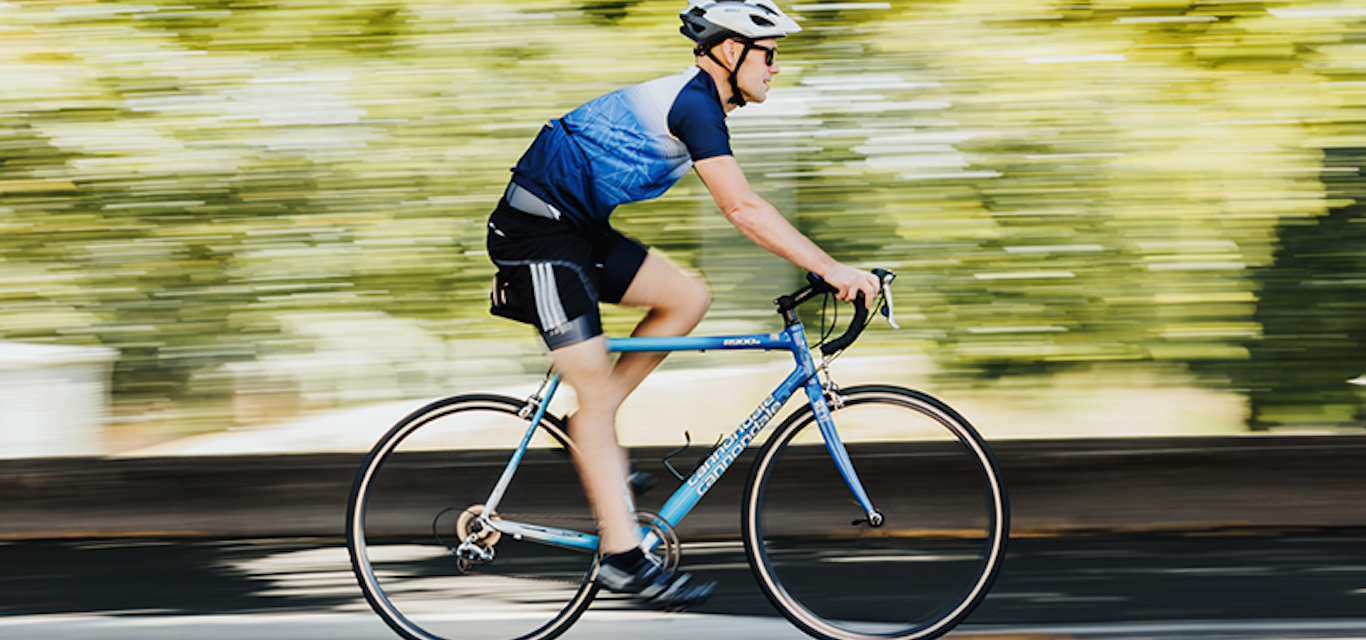 Man riding bike along road