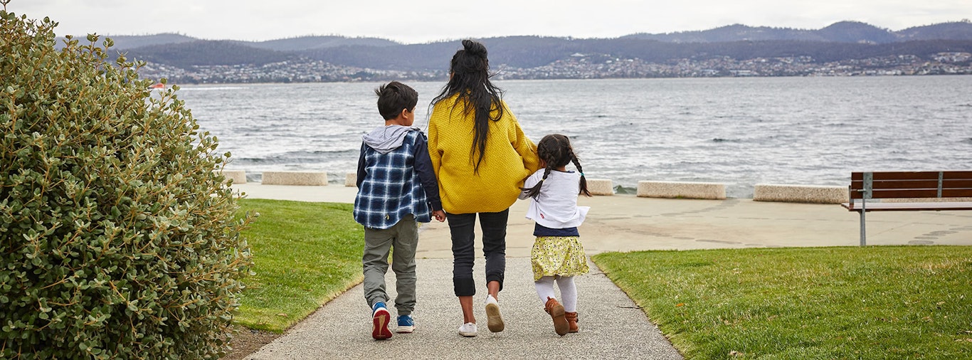 Siblings walking along the Hobart foreshore