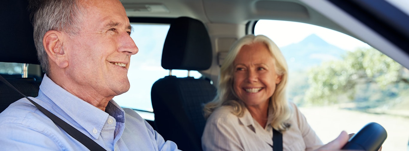 Man driving as woman smiles in passenger seat