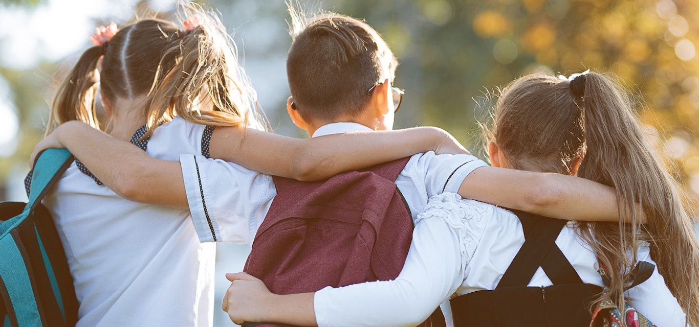 School children with their arms around each other