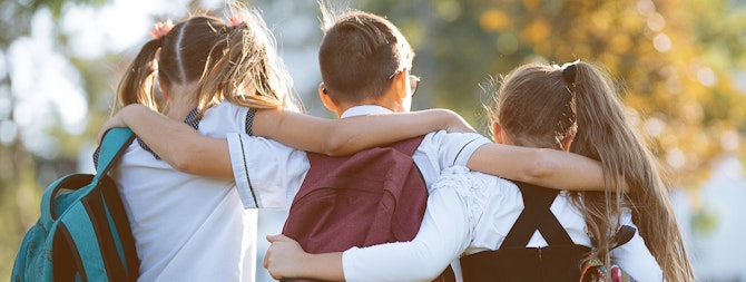 School children with their arms around each other