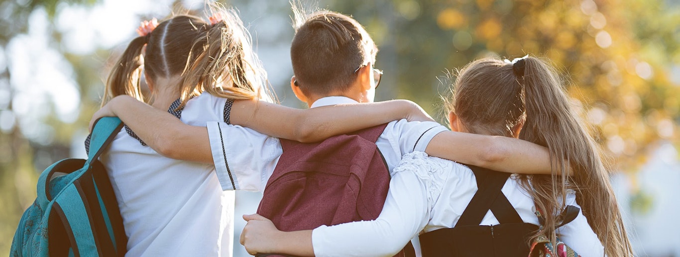 School children with their arms around each other