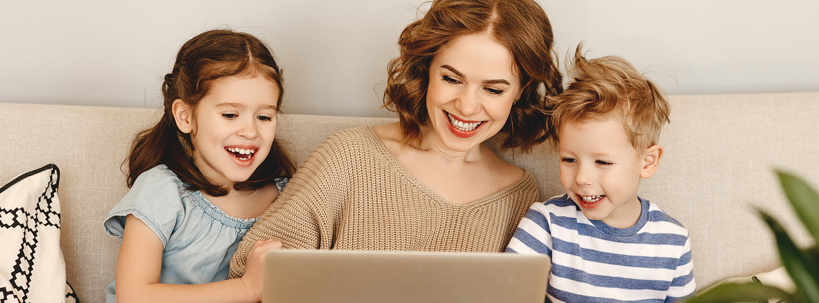 Mum and kids sitting around a laptop