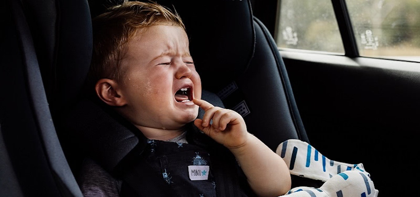 Crying toddler in car seat in a hot car
