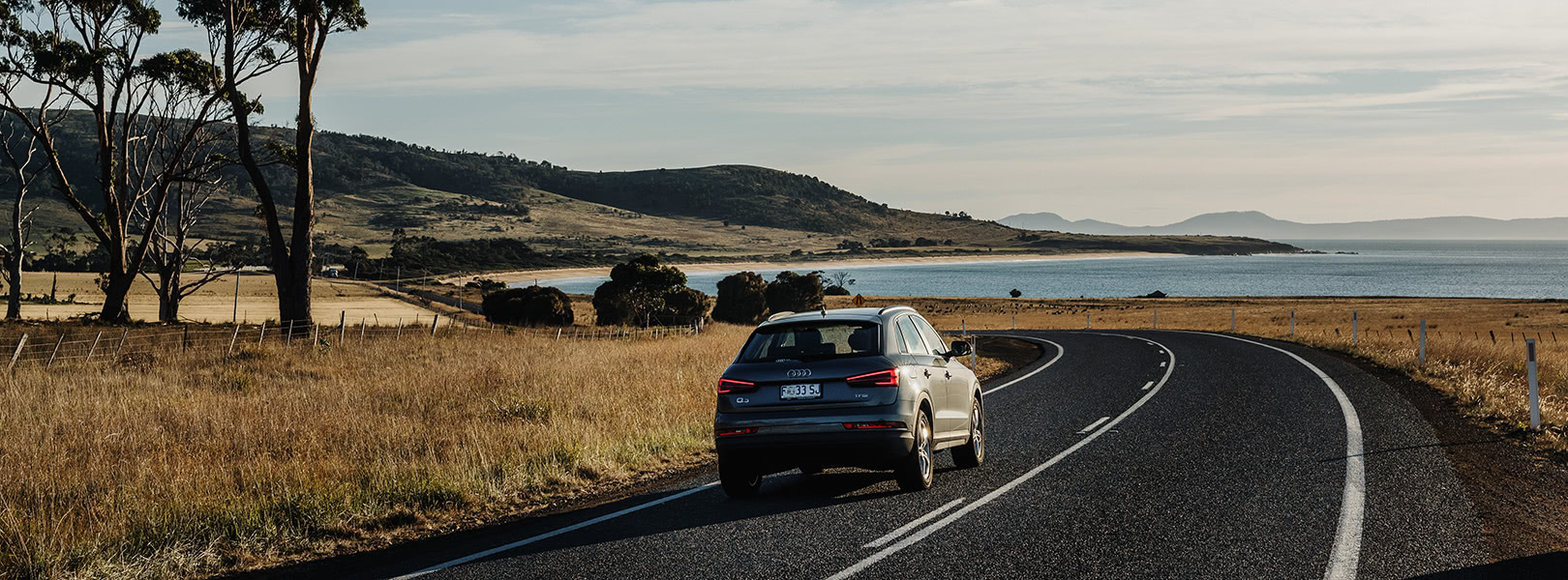 Audi SUV driving along coastal road