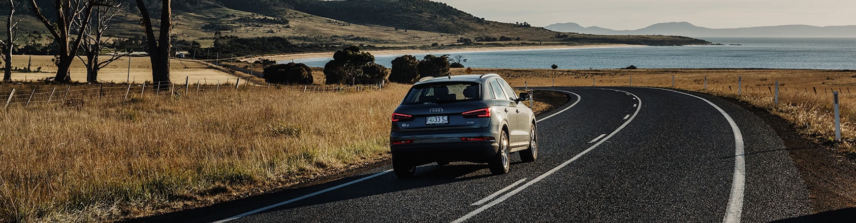 Audi SUV driving along coastal road