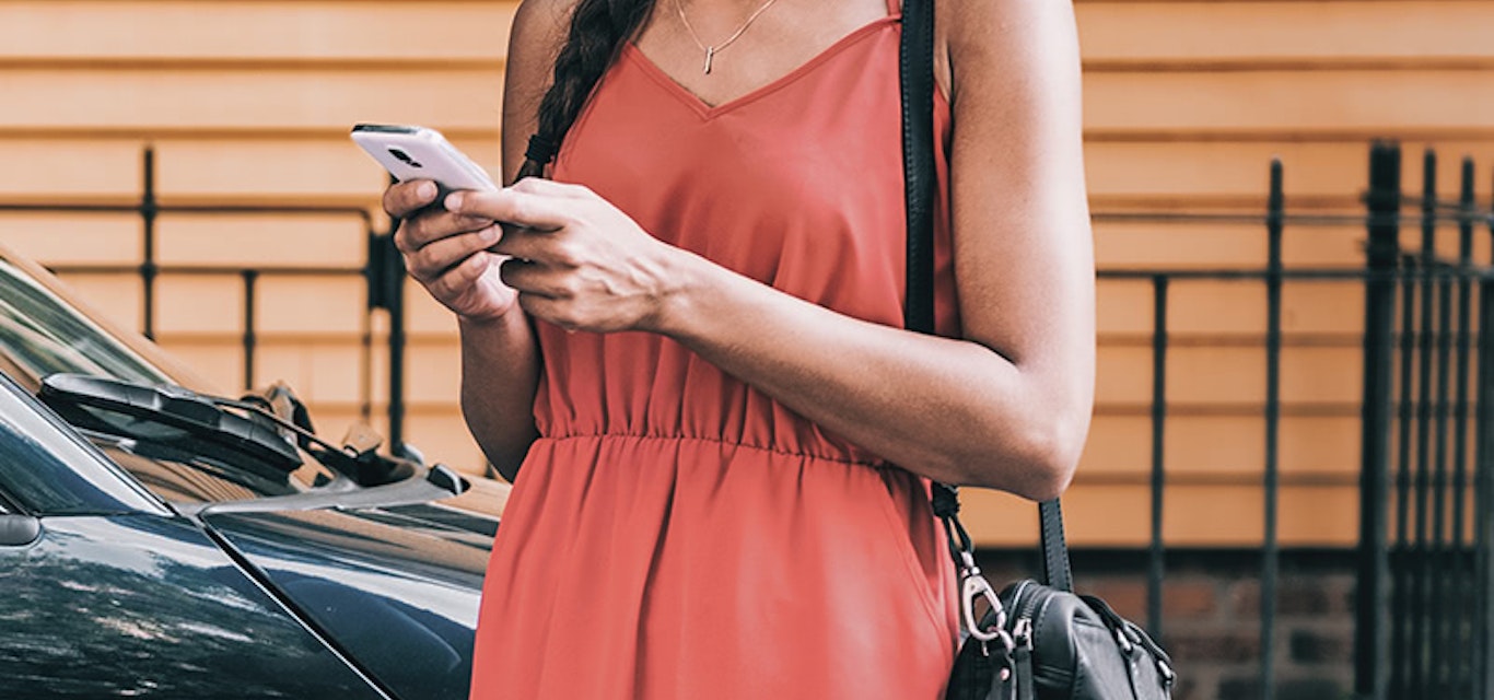 Young lady in red dress looking at her mobile phone