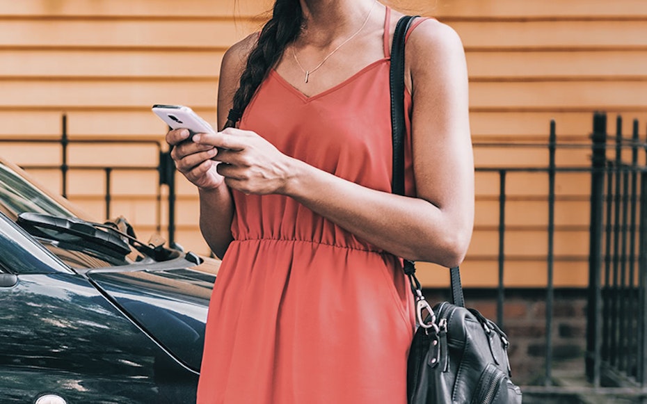 Young lady in red dress looking at her mobile phone