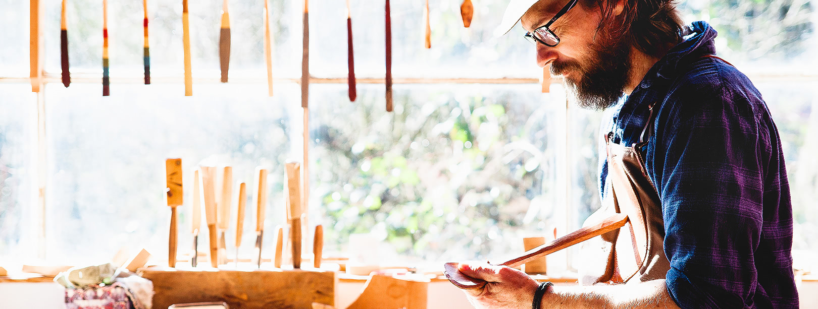Craftsman oiling his finished wooden spoon