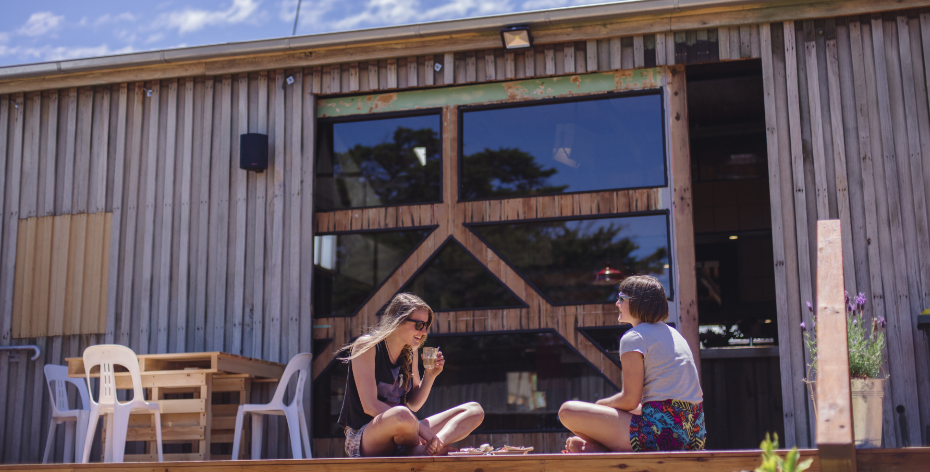 Two people sitting outside Willie Smiths Apple Shed