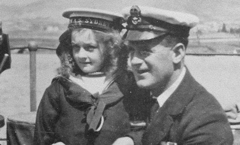 Young girl and sailor pose for photo on the HMAS Sydney