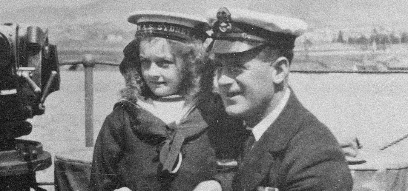 Young girl and sailor pose for photo on the HMAS Sydney