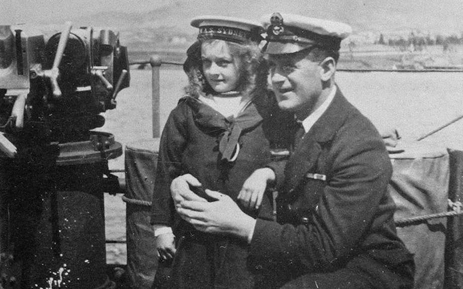 Young girl and sailor pose for photo on the HMAS Sydney