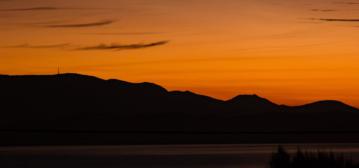 Amazing views from Primrose Sands Sillhouette of Mount Wellington and Hobart in front of an orange sky