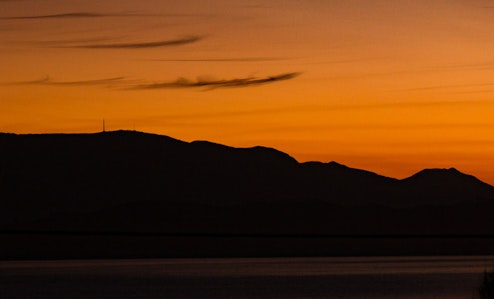 Sillhouette of Mount Wellington and Hobart in front of an orange sky