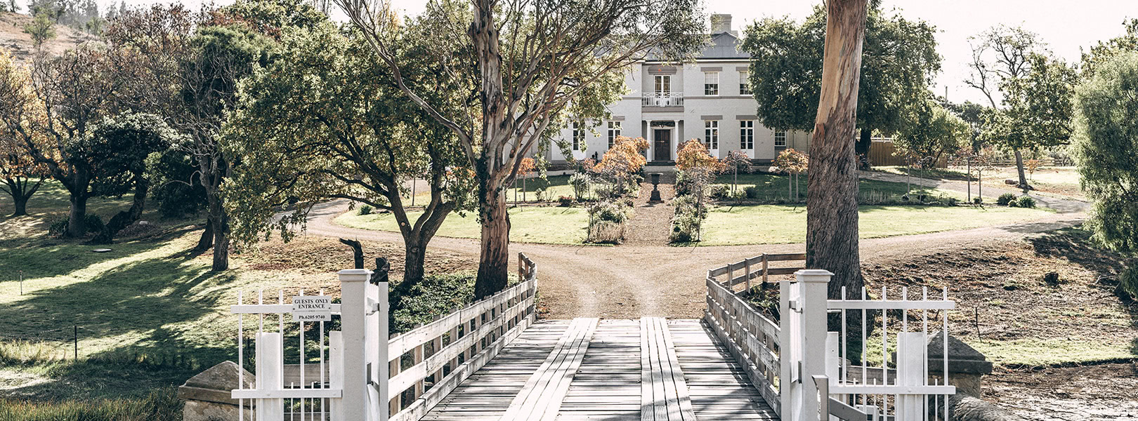 A view of Prospect House through trees and across the entry bridge