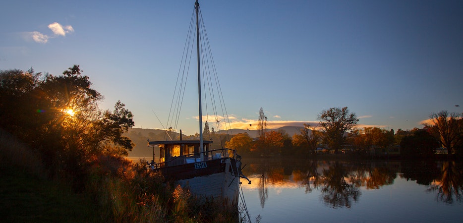 Boat on river during sunrise.