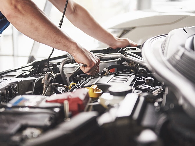 Mechanic fixing engine of car